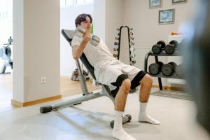 利恩茨Grandhotel Lienz Business-Wellness & Gourmet的坐在健身房椅子上的男人