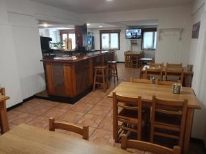 苏马拉加Pension Urola的一间带木桌椅的餐厅和一间酒吧