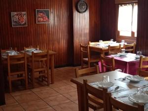 苏马拉加Pension Urola的一间带桌椅和时钟的用餐室