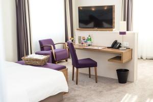 勒讷斯特拉特曼斯酒店的酒店客房配有一张床和一张书桌及一台电视