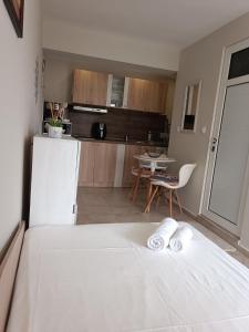 内塞伯尔Megi Apartments, Nesebar sity的一间带白色床的卧室和一间厨房