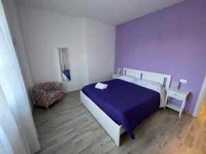 斯特雷萨Villa Vittoria的紫色卧室配有一张床和一把椅子