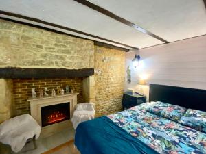 萨尔拉拉卡内达La Clef des Songes B&B de charme - Sarlat Centre - Parking gratuit - Piscine et espace bien-être à 400mètres的一间卧室配有一张床和一个壁炉