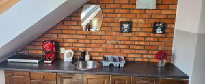 卡托维兹Apartamenty Madera的一个带水槽和砖墙的厨房台面