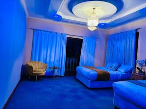 姆巴巴内GoldenWays Motel的蓝色客房 - 带床和椅子