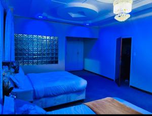 姆巴巴内GoldenWays Motel的蓝色的客房配有床和沙发