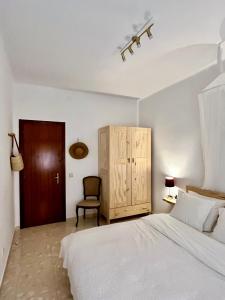 卡尔多纳Can Bastida的卧室配有白色的床和椅子