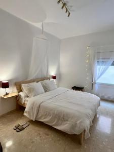 卡尔多纳Can Bastida的卧室设有一张白色大床和一扇窗户。