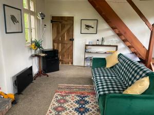 兰德林多德威尔斯Wye Riverside Lodge的客厅设有绿色沙发和门。