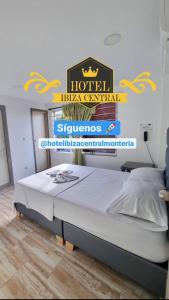 蒙特里亚Hotel ibiza Central的墙上有标牌的房间的一张床位