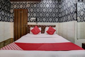 孟买OYO Flagship Hotel Sapna Residency的一张带红色枕头的床
