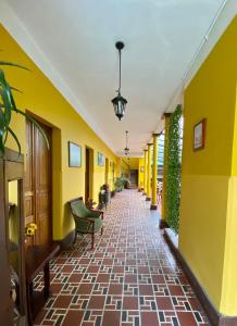索波Hotel Villa Mercedes Colonial的黄色墙壁的建筑走廊