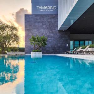 罗勇Tamarind Garden Hotel - SHA Plus Certified的大楼前的大型游泳池