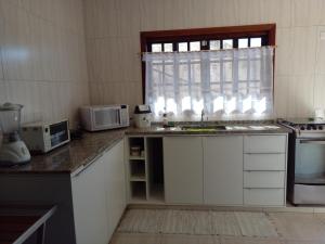坎波斯杜若尔当Casa dos Neves的厨房配有水槽、微波炉和窗户