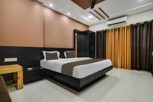 印多尔Collection O Santushti Hotel & Restaurant的一间卧室配有一张床、一张桌子和一张四柱床。