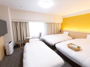 富山富山希泰茨酒店的酒店客房设有两张床和黄色的墙壁