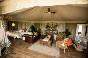奥托罗杭阿Orchard Valley Glamping的一间卧室配有带床和家具的帐篷