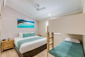 埃尔利海滩四大冒险圣灵假日公园的一间卧室配有两张床和一张双层床。