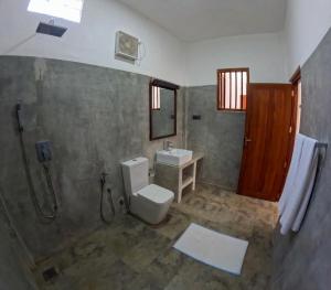 迪克韦勒SurfBayVilla的浴室配有卫生间、盥洗盆和淋浴。