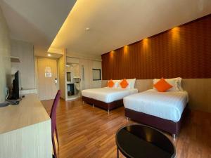 合艾东娜奥大酒店的酒店客房设有两张床和电视。