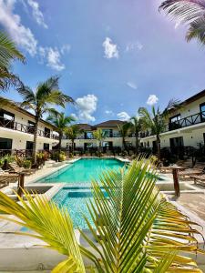 布韦朱Sand Beach Boutique Hotel的度假村前方棕榈树游泳池