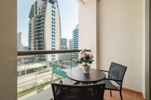 迪拜Sunkissed holiday homes 2-3BR Apartments on JBR beach near mall & metro & bluewaters Island的阳台上的桌椅和花瓶