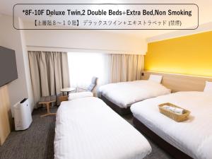 富山富山希泰茨酒店的酒店客房带两张床,还有酒店标志