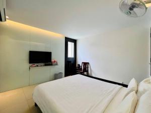 岘港Holiday Inn Hotel的卧室配有白色的床和平面电视。