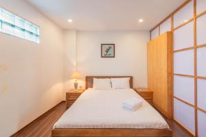 河内22housing Residence Suites 20 linh Lang的一间卧室设有床、两张桌子和一扇窗户