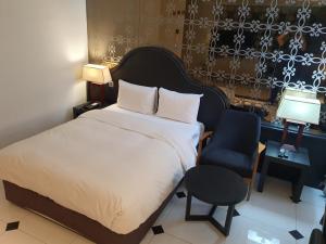 首尔明洞多玛酒店的一间卧室配有一张床、一把椅子和一张书桌