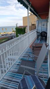 卡内·德·玛尔Canet playa y centro的一个带椅子和遮阳伞的阳台,并享有海景。