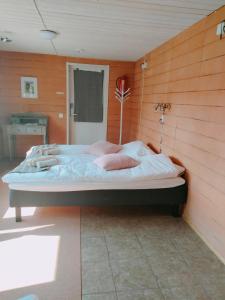 AlatemmesB&B Villa Helmi的卧室配有一张木墙内的大床