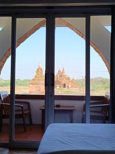 蒲甘Myanmar Nan Hteik Temple View Hotel的客房可通过窗户欣赏到大楼的景色