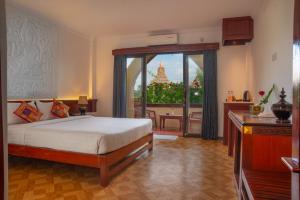 蒲甘Myanmar Nan Hteik Temple View Hotel的一间卧室设有一张床和一个美景阳台