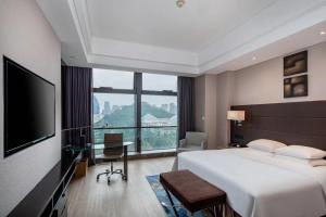 贵阳贵阳万丽酒店的酒店客房设有一张大床和一张书桌。
