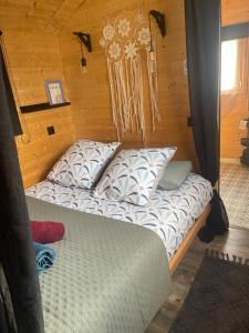 索利耶蓬Roulotte , hébergement atypique的木墙客房的一张带枕头的床