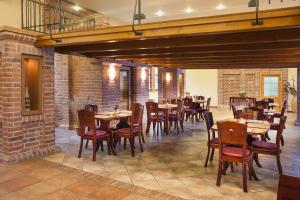 米库洛夫Hotel Aurelius Mikulov的餐厅设有木桌和椅子,拥有砖墙