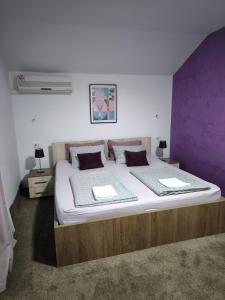 莫斯塔尔无限旅馆的一间卧室配有一张大床和紫色墙壁