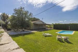 弗拉加Mas de l' Anneta的一个带椅子的庭院和一个游泳池
