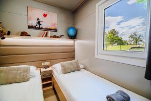 卡特兹奥布萨维DELUXE Lake View Mobile Homes with Thermal Riviera Tickets的小型客房 - 带2张床和窗户