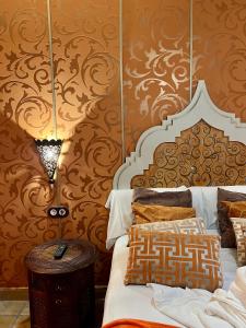 桑提亚纳德玛波萨达传奇酒店的一间卧室配有床和装饰华丽壁纸的墙壁
