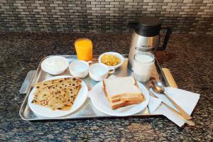 拉塔古里Hotel Green Gold Resort Lataguri的盘子,包括面包和烤面包在桌子上