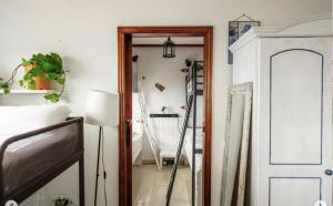 Almáciga卡萨那格公寓的卧室配有镜子,旁边是一张床和一盏灯