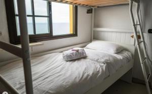 Almáciga卡萨那格公寓的一间卧室配有双层床和窗户。