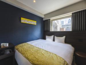 东京池袋永安国际酒店的一间卧室设有一张大床和窗户
