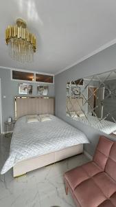 索波特Gold Glamour Apartment Sopot z dwoma sypialniami, duzy balkon的一间卧室配有一张大床和一个吊灯。
