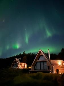 埃基斯蒂尔Hengifosslodge Tiny Houses的天空中光辉的两座建筑