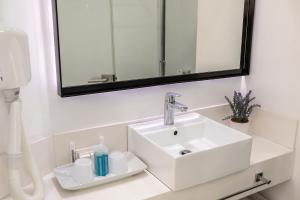 普罗塔拉斯水晶温泉海滩酒店的浴室设有白色水槽和镜子