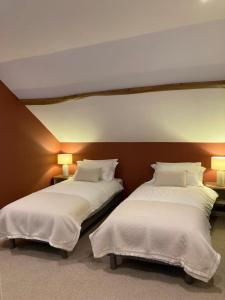 Salon-la-TourChambres & Table d'hôtes de La Vieille Ferme的配有白色床单的酒店客房内的两张床