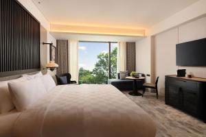 三宝垄Padma Hotel Semarang的一间酒店客房,设有一张大床和一个大窗户